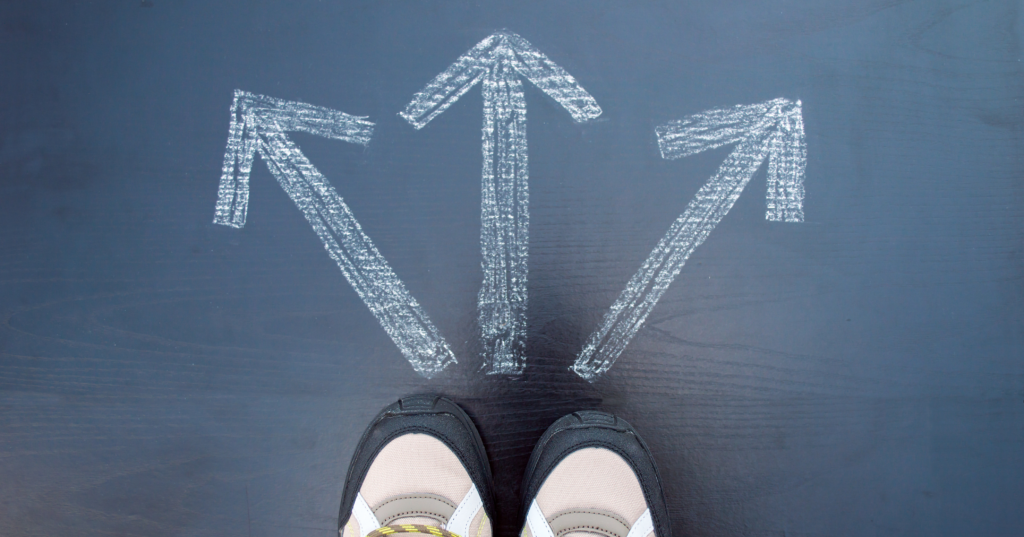 黒い床に描かれた三方向の矢印の前に立つ足元。恋の選択を占いで考えるイメージ