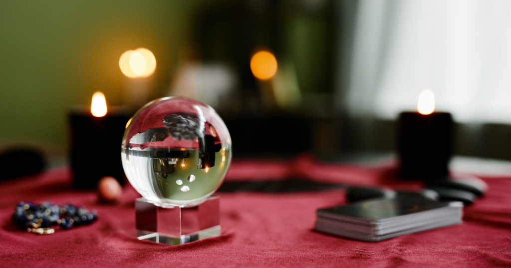 テーブル上の水晶玉とキャンドル、カード。恋の占い鑑定を連想する写真